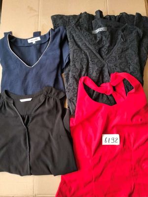 three women ' s tops are sitting on a cardboard box with a price tag