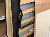 a bed with a wooden frame and a black bag on top of it