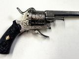 pistolet posé sur une surface blanche, avec une poignée noire et une poignée noire
