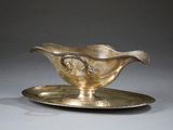 un service en argent ancien composé d'une assiette et d'une soucoupe posée dessus