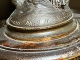 a bronze statue of a cat sitting on top of a table