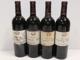 four bottles of wine are lined up on a white surface