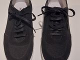 pair of black sneakers with white soles on a white surface