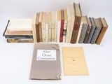 an assortment of books are stacked on top of each other on a table