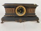 une horloge noire et dorée ornée de personnages