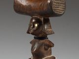 an image of a wooden sculpture of a man holding a large piece of wood