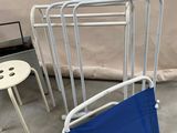 a blue and white folding bed next to a white table