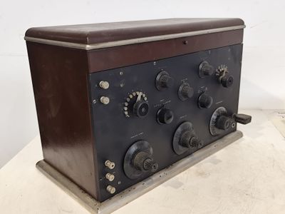 une vieille radio posée sur une table en bois, près d'un mur blanc