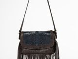 un sac à main marron et bleu orné de franges, suspendu à un crochet