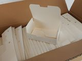 a cardboard box filled with white papers on a table