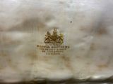 a white bag with a gold emblem on it