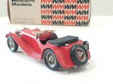 a red toy car sitting on a table next to a box of western models