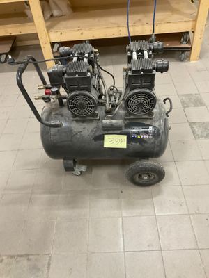 deux compresseurs d'air posés sur un chariot dans une pièce