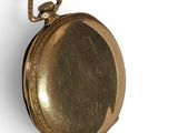 a gold colored pocket watch hanging on a rope