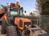 a tractor that is parked next to a yellow plow