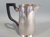 a silver pitcher with a handle on a table