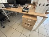 a desk with two monitors and a file cabinet in front of it
