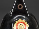 a black fireman ' s helmet with a gold badge on it
