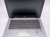 a silver laptop with a black keyboard on a white table