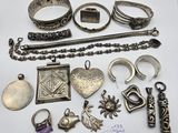 several silver jewelry items are displayed on a white surface