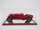 an old model of a red car in a glass case