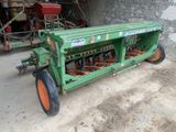 un tracteur vert aux roues orange garé dans un garage