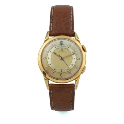 gros plan d'une montre sur une surface blanche avec un bracelet marron