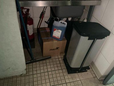 an image of a kitchen with a sink and a trash can