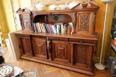 une grande armoire en bois sur laquelle sont posés de nombreux livres