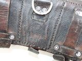 a brown leather case with metal handles on a white surface
