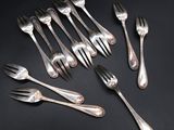 six forks and six spoons are arranged on a black surface