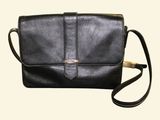 a black leather purse with a gold clasp on the front