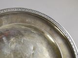 a silver plate on a table with a white background