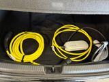 two cables in the trunk of a car connected to a charger