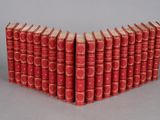 six red books stacked on top of each other on a gray surface