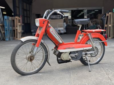 un cyclomoteur rouge garé dans un garage