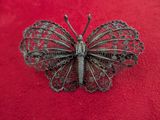an antique butterfly broochle on a red background