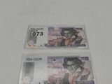two pieces of money sitting next to each other on a table