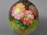 a vase with flowers painted on it sitting on a table