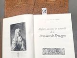 un livre ouvert posé sur une table, à côté d'un tableau en liège
