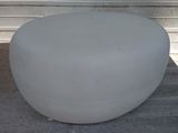 a large white stool sitting on a concrete floor
