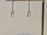 a pair of earrings that are on a stand