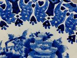 a blue and white plate with flowers and birds on it