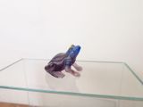 a glass table with a figurine of a frog on it
