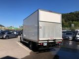 a white truck parked in a parking lot next to other cars
