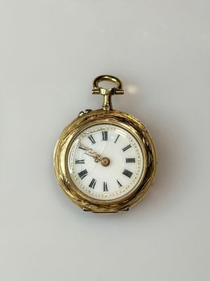 a gold pocket watch with roman numerals on it