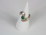 a close up of a ring with a green stone on it