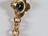 gold tone bracelet with green and blue glass beads on a white mannequin
