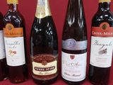 several bottles of wine are lined up on a red surface