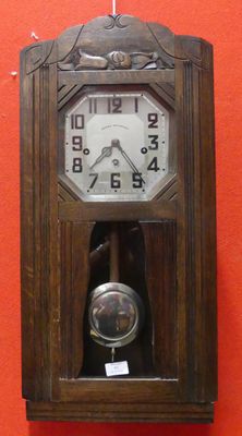 une horloge en bois accrochée au mur, avec un mur rouge en arrière-plan